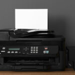 black-wireless-printer-on-console-table-next-to-printer-paper-and-wooden-globe