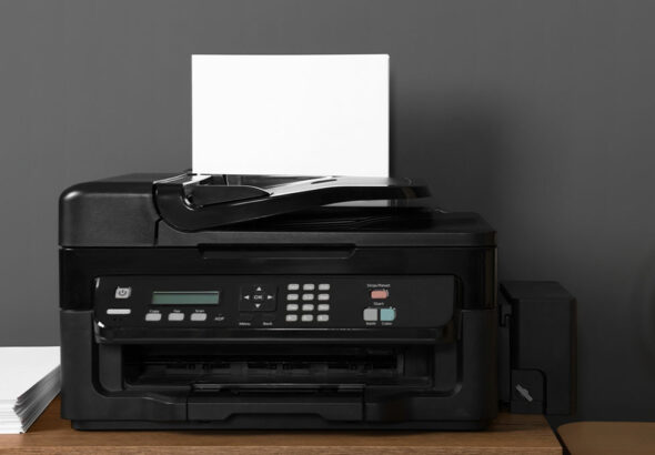 black-wireless-printer-on-console-table-next-to-printer-paper-and-wooden-globe